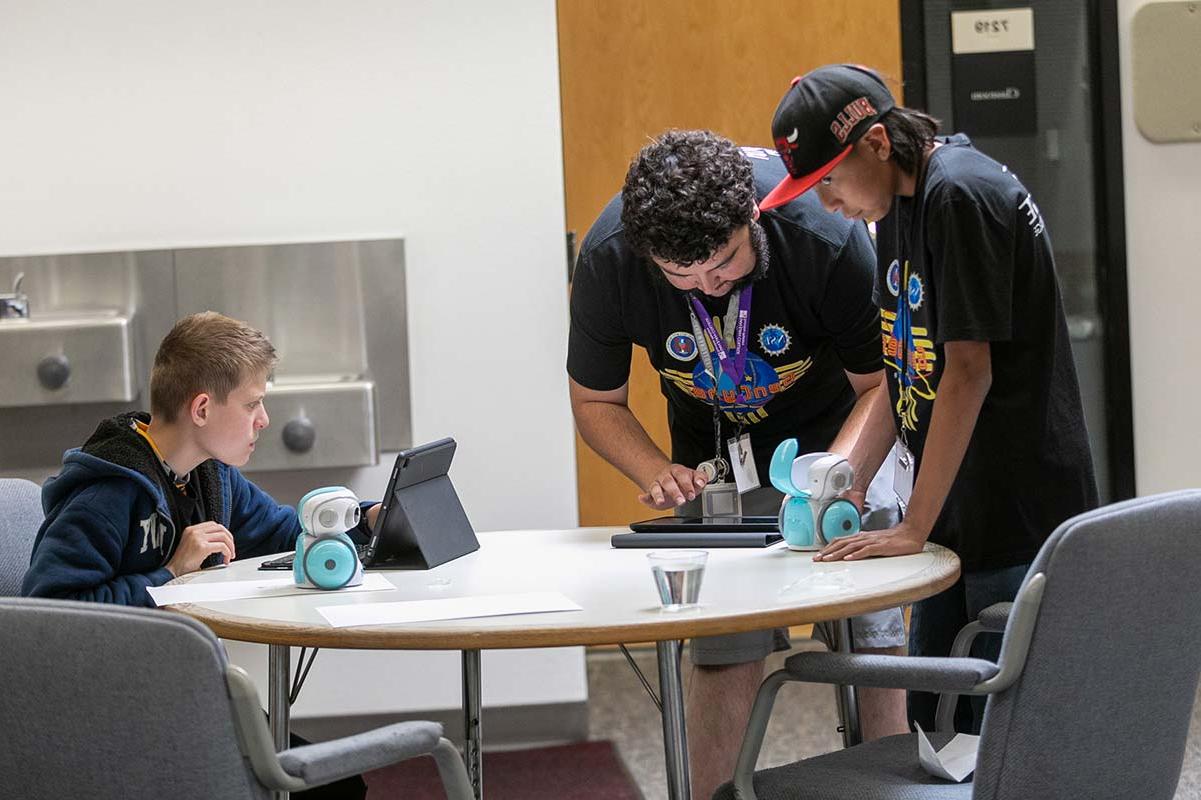 学生们在GenCyber夏令营2023中与他们的机器人一起工作.